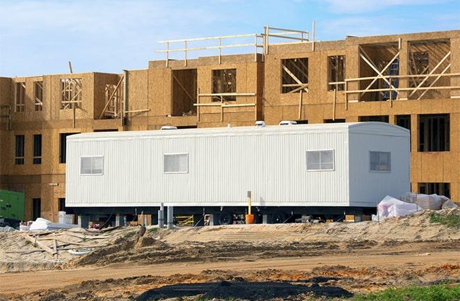 crane lifting modular building for construction office rentals in Atwood